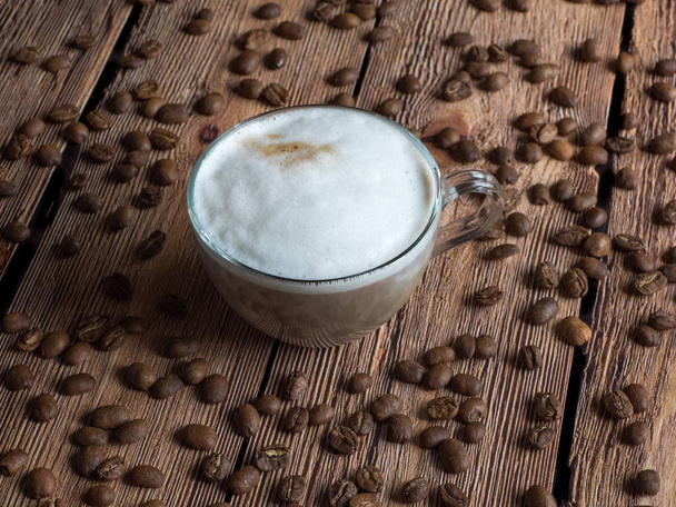 Чашка кави в руках на коричневому дерев'яному столі
 - Фото, зображення