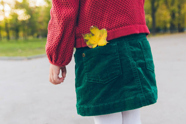 holčička v městském parku žlutý javorový list v slyšet zadní kapse - Fotografie, Obrázek