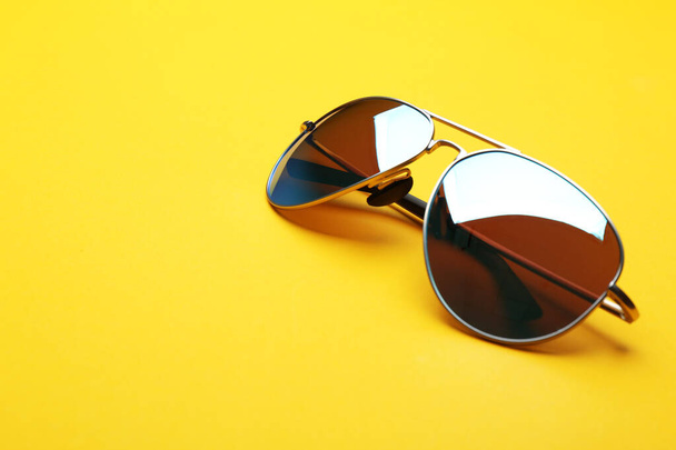Stylish sunglasses on yellow background, space for text. Fashionable accessory - Foto, afbeelding