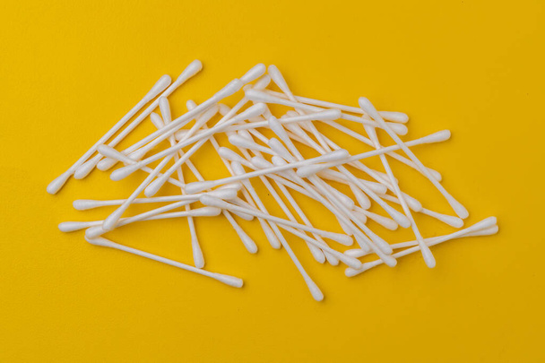 bunch of cotton ear sticks swabs on yellow surface, macro views - Photo, Image