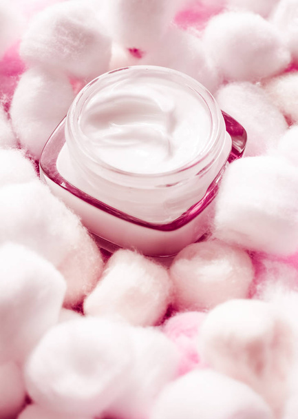 Crema viso di lusso per pelli sensibili e batuffoli di cotone rosa su ba
 - Foto, immagini