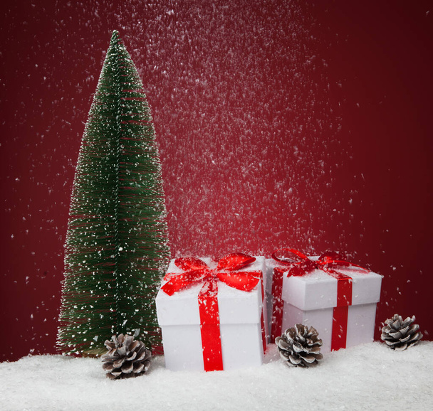 White gift boxes and fir tree on red background. Copy spase for text - Foto, Imagem
