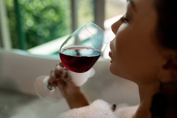 Close-up photo of brunette posing with a glass of wine - Photo, image