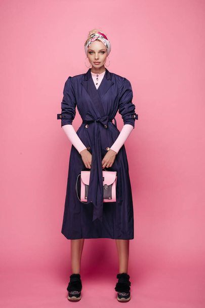 Модна стильна дівчина позує з стильною жіночою сумкою ізольовано на рожевому студійному фоні повний постріл
 - Фото, зображення