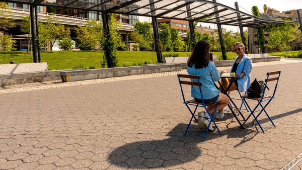Mère et fille assis à la table de café avec parc dans le backg
 - Photo, image