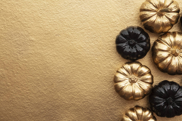 Luxo ouro e preto outono abóbora plana composição leigos em um fundo de ouro
 - Foto, Imagem