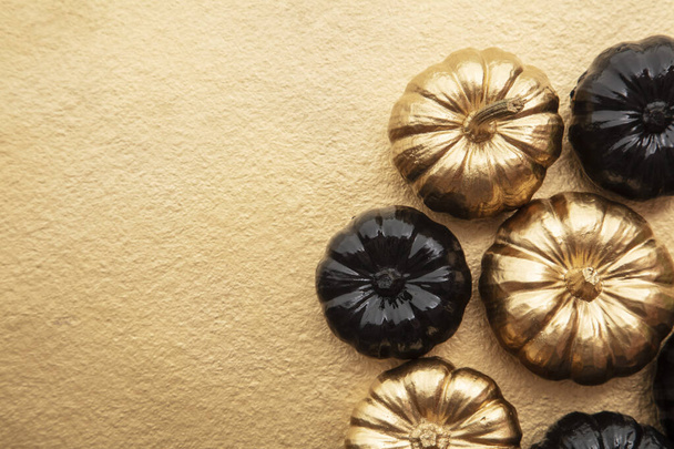 Luxury gold and black autumn pumpkin flat lay composition on a gold background - Fotó, kép