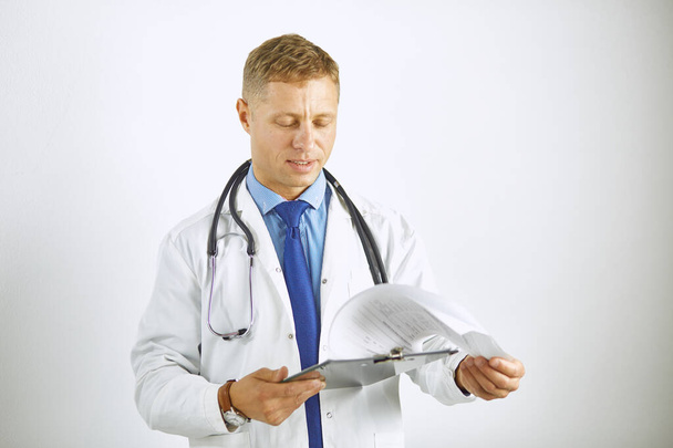 Junger selbstbewusster Arzt im weißen Kittel mit Stethoskop - Foto, Bild