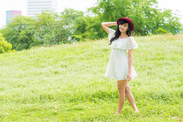 Jolie jeune asiatique de la mode femmes relaxant dans vert ville public p
 - Photo, image