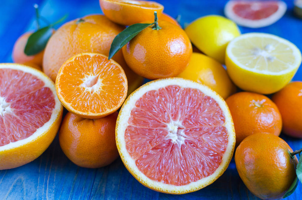 Цитрусовые мандарины апельсины лимоны лайм крупным планом на голубом фоне
 - Фото, изображение