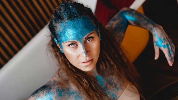 Portrait of beautiful woman with sparkles on her face. Girl with art make up - Foto, Bild