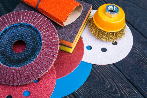 Set of abrasive tools and sandpaper different colors on black vintage wooden background - Photo, Image