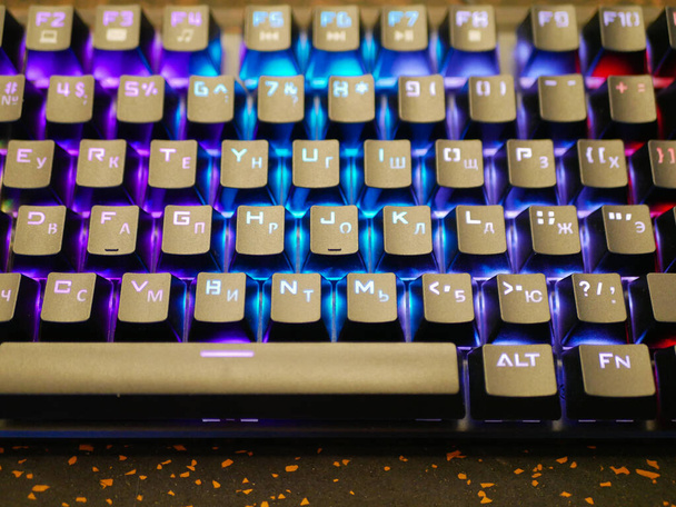 multi-colored keyboard. mechanical keys. Multi-colored professional gaming mechanical rgb keyboard on the table background  - 写真・画像