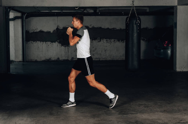 М'язи чоловіка тренують бойові мистецтва в підземному гаражі
 - Фото, зображення