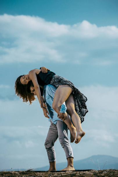 Beau homme avec une belle jeune fille dansant breakdance sur la colline de montagne
 - Photo, image