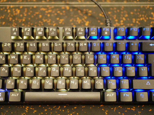 multi-colored keyboard. mechanical keys. Multi-colored professional gaming mechanical rgb keyboard on the table background  - Foto, afbeelding