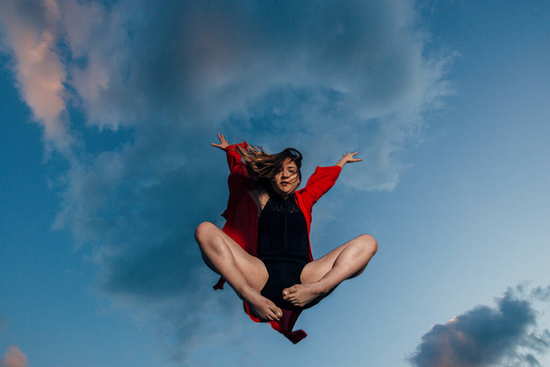 Силуэт взволнованной женщины, прыгающей на закате
 - Фото, изображение