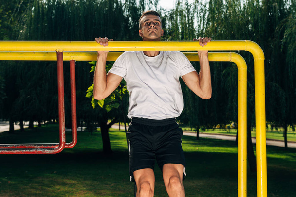 CrossFit człowiek robi pull-up na drążek podczas treningu na zewnątrz - Zdjęcie, obraz