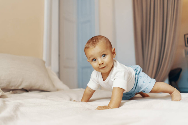 寝室のベッドの上で這う赤ん坊の肖像画 - 写真・画像