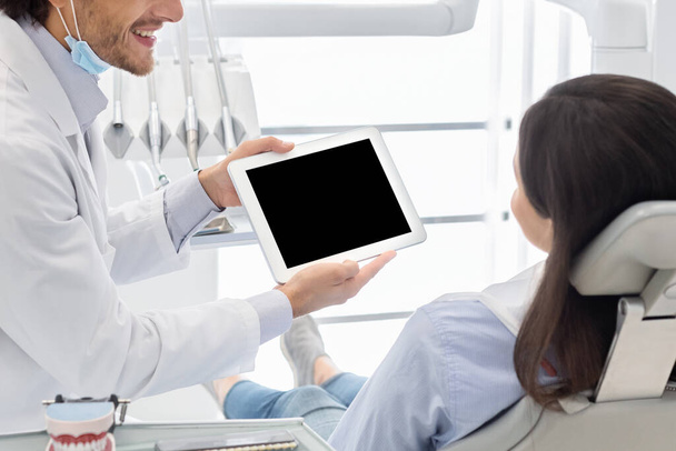 Close up of empty digital tablet screen showing by dentist - Photo, image