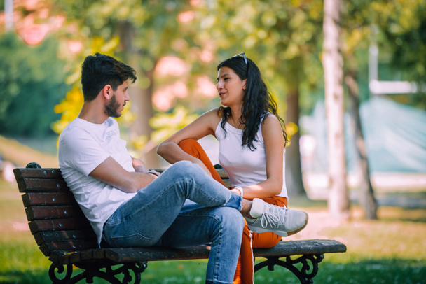 若いカップルが公園でお互いに口論ベンチに座っています - 写真・画像