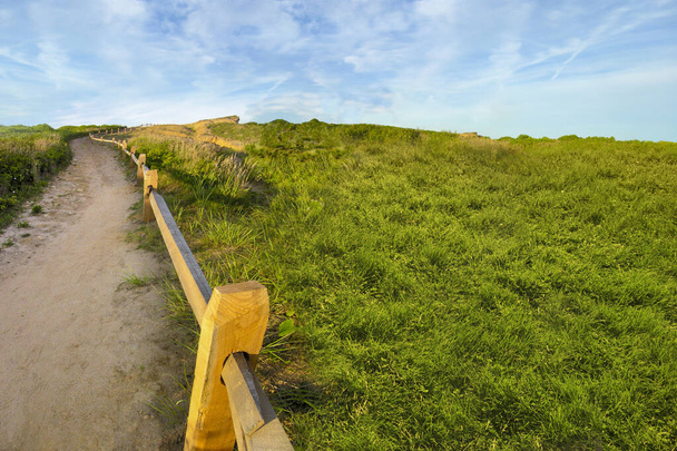 terrain herbeux avec saleté tral avec clôture en bois avec lever de soleil doré s
 - Photo, image