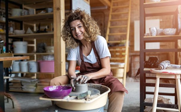 Woman making ceramic work with potter's wheel - Valokuva, kuva
