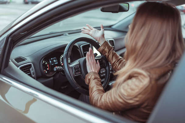 woman screams aggressively, clicks signal beep steering wheel car, passenger compartment, city intersection summer, accident emergency braking, violation traffic rules, emotions rage stress conflict. - Foto, afbeelding
