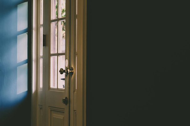 Licht en schaduw abstract.Sun schaduwrijke witte houten deurkozijn en paneel. Laat in de middag zonlicht zorgt voor lijnen en schaduw. - Foto, afbeelding