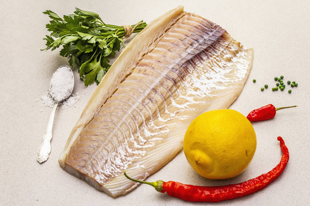 Raw cod loin fillet with lemon, sea salt, chili and cayenne pepper, parsley - Foto, Imagem