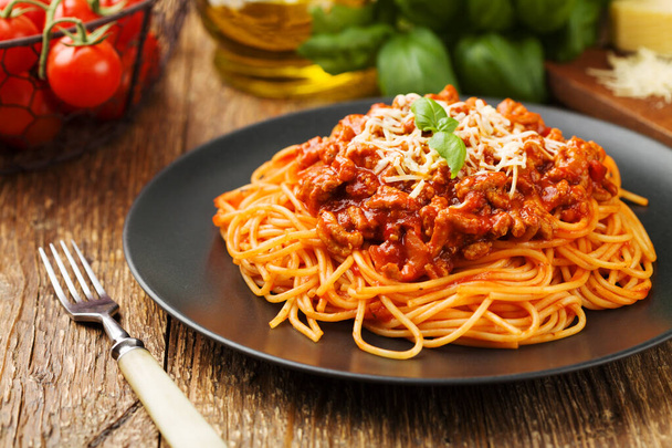 Delicious spaghetti served on a black plate - Foto, afbeelding