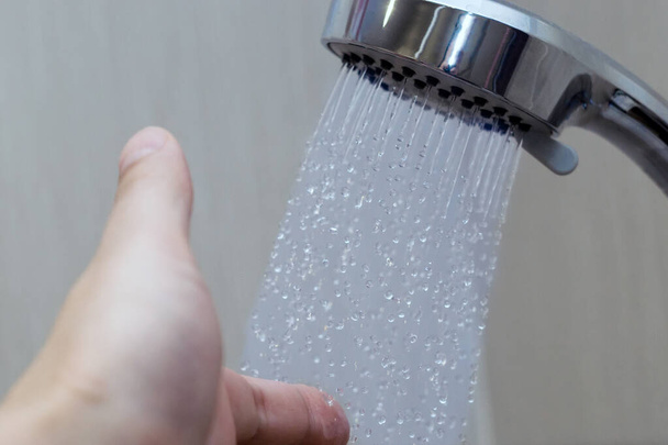 mano en la ducha prueba temperatura del agua
 - Foto, imagen