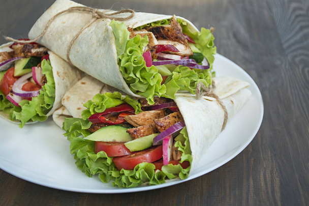 Mexická jídla.Taco s kuřecím masem a zeleninou zblízka na dřevěném pozadí. Mezera pro text. - Fotografie, Obrázek