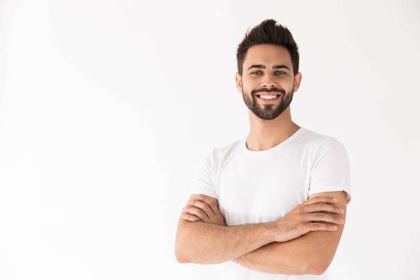Image of attractive young man smiling at camera with arms crossed - Photo, Image