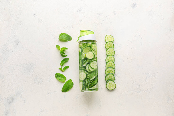 Bottle of healthy infused water with ingredients on light background - Photo, Image