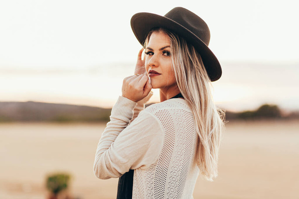 Portrait of beautiful woman wearing fedora hat outdoors - Zdjęcie, obraz