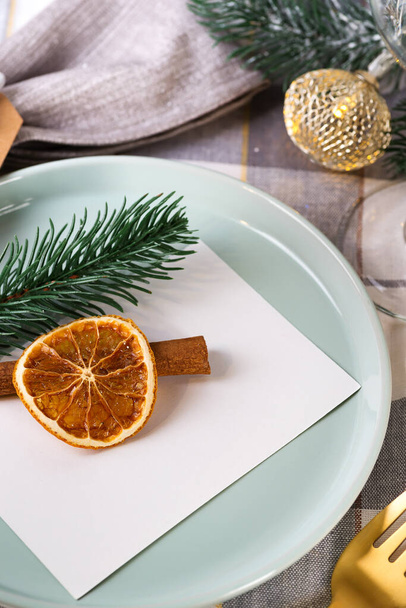 Festive Christmas and New Year details table setting with dry orange and cinnamon on a gray textile. Dining place decorated - Foto, immagini
