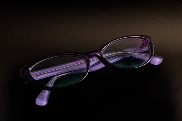 Gafas violetas para visión sobre fondo negro
 - Foto, imagen