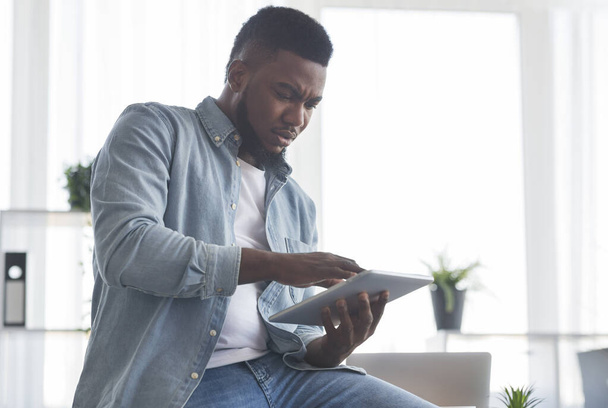 Портрет зацікавленого чорного працівника з використанням цифрового планшета в офісі
 - Фото, зображення