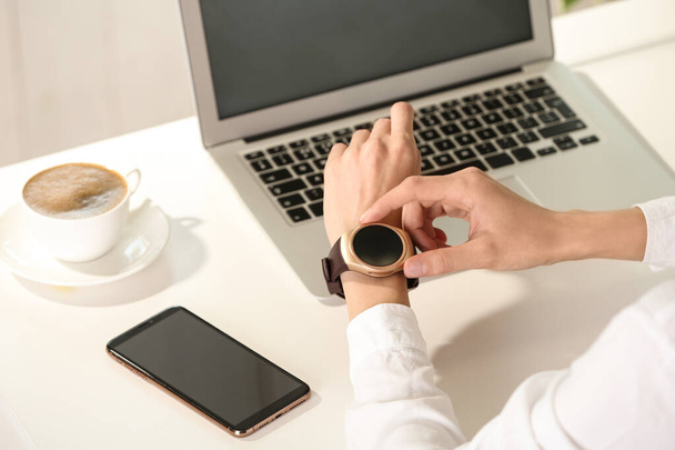 Woman using smart watch at table indoors, closeup - Foto, immagini