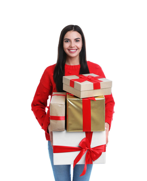 Happy young woman holding Christmas gifts on white background - Foto, imagen