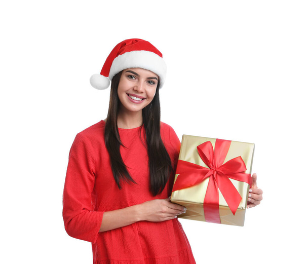 Happy young woman in Santa hat holding Christmas gift on white background - Foto, Imagem