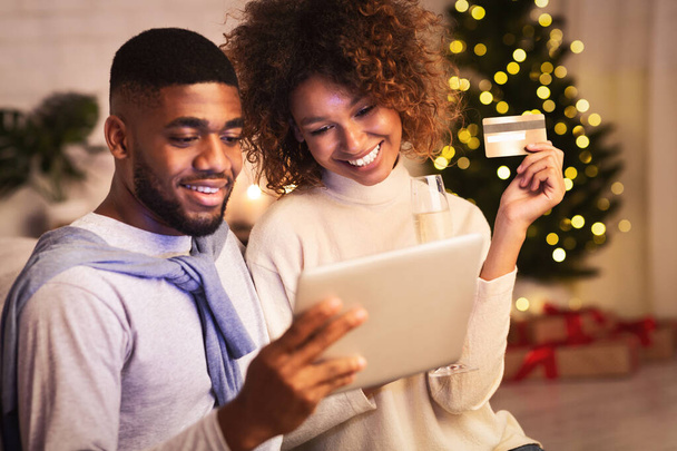 Préparation de Noël. heureux noir couple achat cadeaux en ligne
 - Photo, image