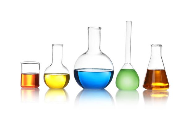 Laboratory glassware with color liquids on white background - Zdjęcie, obraz