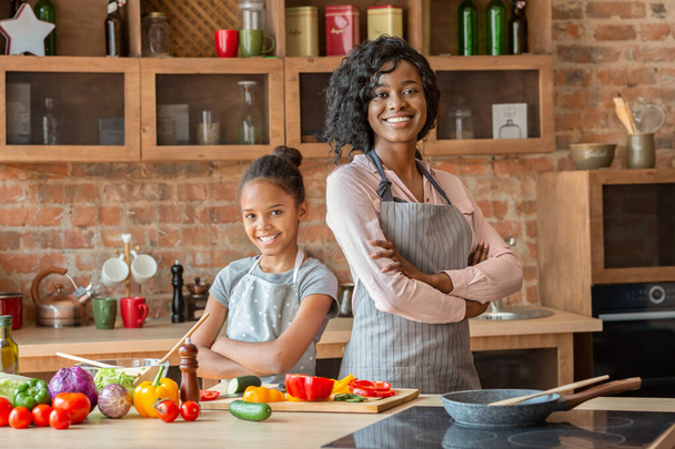 Confident mom and daughter posing on camera while cooking - Photo, Image