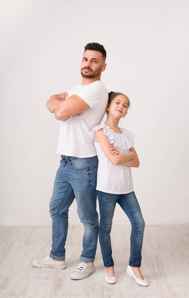 Confident daddy and daughter posing back to back with crossed hands - Valokuva, kuva