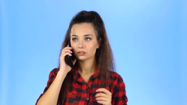 Young woman speaking by phone and smiling - Filmagem, Vídeo