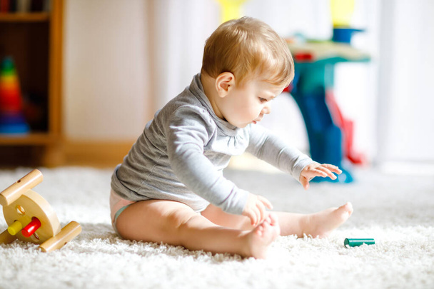 Adorable baby girl playing with educational toys . Happy healthy child having fun with colorful different wooden toy at home. Early development for children with nature toy. - Fotoğraf, Görsel