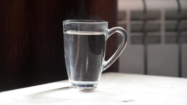 Préparez un sachet de thé noir. Coupe transparente avec eau chaude sur fond noir
. - Séquence, vidéo