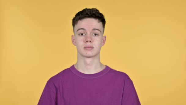 Young Man Pointing at Camera on Yellow Background - Кадры, видео